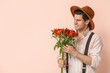 © Pixel-Shot - Handsome man with bouquet of flowers on color background