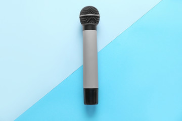 Modern microphone on color background