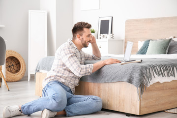 Poster - Young man with laptop working at home