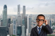 © len4foto - concept of leadership and success - thoughtful african american boy in business suit with glasses over singapore city background.