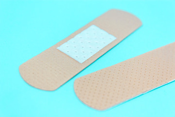 skin color medicine adhesive healing bandage layout on blue background. medical aid healing patch co