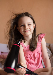 5 years old girl blow dry her hair in her room