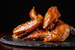 © zukamilov - American cuisine. Fried chicken wings glazed in honey sauce on a black background. background image, copy space text