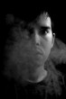Concept. Smoke enveloped the man’s head. Portrait on a black background a man with smoke. Second hand smoke.