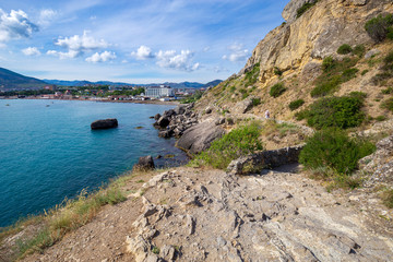 Wall Mural - Beautiful summer sea landscape at the resort in the Crimea. View of the city from the mountain trail. Rocky coast of the black sea. Seascape.