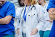 © Halfpoint - Group of unrecognizable doctors walking in corridor on conference.