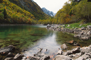 Turquoise Baduk lake in mountains in Dombay national park, Caucasus, Russia. Beautiful autumn landscape.