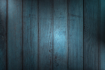 Wall Mural - Vertical wooden planks with peeling blue paint, creative lighting and copy space. Abstract trendy wooden natural texture background