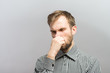 © aeroking - Closeup portrait of young man, disgust on face, pinches his nose, something stinks very bad smell, situation, asking is it you, isolated on gray background. Negative emotion facial expression feeling