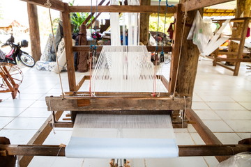 handicraft cotton or silk weaving on wooden loom machine , occupation of villagers at workplace in rural . ancient from asian Thai culture made a clothes for life and for community small business .