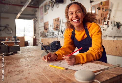 Fotografía Female Craftsman In Carpentry Workshop For Bamboo Bicycles Using Digital Tablet