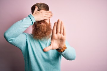 Poster - Handsome Irish redhead man with beard wearing glasses over pink isolated background covering eyes with hands and doing stop gesture with sad and fear expression. Embarrassed and negative concept.