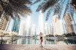 Bright and clean overlooking lake view in an urban city emirates gulf country lifestyle. Russian lady photography in the city with tall building in surroundings.