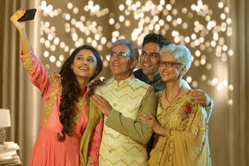 Indian family taking selfie or self photograph at home on diwali festival
