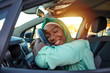 © Dragana Gordic - Young Muslim African Woman Embracing Her New Car. Excited young woman and her new car indoors. Young and cheerful woman enjoying new car hugging steering wheel sitting inside