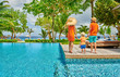 © haveseen - Family of three by poolside. Resort swimming pool at Seychelles.