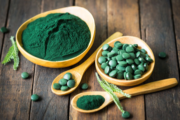 Spirulina tablets and powder in bowls