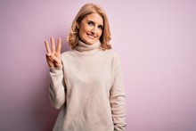 Middle Age Beautiful Blonde Woman Wearing Casual Turtleneck Sweater Over Pink Background Showing And Pointing Up With Fingers Number Three While Smiling Confident And Happy.