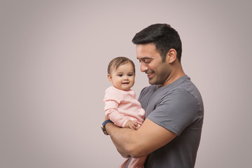 smiling father playing baby girl