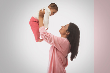 Smiling Mother lifting baby
