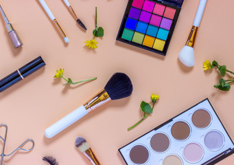 Accessories for professional decorative cosmetics.  Makeup brushes eye shadow  contouring palette contour lipstick eyelash curler  false eyelashes  on color background.  Flat lay top view.