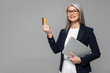 © LIGHTFIELD STUDIOS - happy asian businesswoman with grey hair shopping online with credit card and laptop isolated on grey