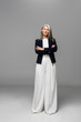 © LIGHTFIELD STUDIOS - confident asian businesswoman with grey hair and crossed arms on grey