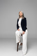 © LIGHTFIELD STUDIOS - asian stylish businesswoman with grey hair sitting on stool on grey