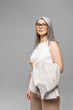 © LIGHTFIELD STUDIOS - confident asian businesswoman in eyeglasses isolated on grey