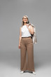 © LIGHTFIELD STUDIOS - happy asian businesswoman in eyeglasses standing on grey