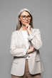 © LIGHTFIELD STUDIOS - thoughtful professional asian businesswoman in eyeglasses isolated on grey