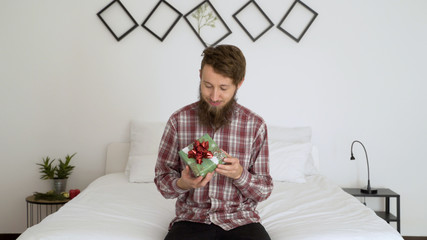 Wall Mural - Happy man holding a present in an authentic room.