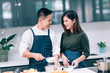 © DJ Creative Studio - Young Adult Couple Food Cooking Together in the Kitchen at Home