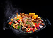 © Alexander Raths - Assorted delicious grilled meat with vegetables on barbecue isolated on black background