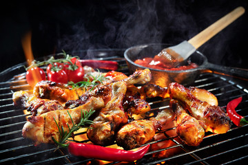 Grilled chicken legs or drumsticks on the hot flaming grill