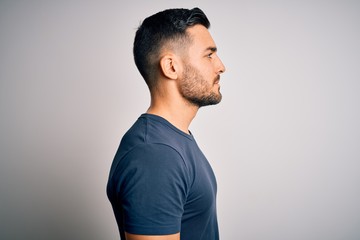 young handsome man wearing casual t-shirt standing over isolated white background looking to side, r