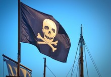 Low Angle View Of Pirate Flag On Boat Against Clear Sky