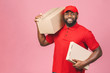© denis_vermenko - Delivery concept. African american delivery black man carrying parcel isolated over pink background.