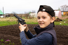 A Boy In A Black Cap Shooting A Pistol At Targets. Weapon. Sport Shooting.
