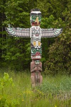 Totem Pole In Greenery In Stanley Park Near Vancouver, Canada