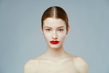 Portrait of attractive sexy woman with red lips posing grey background. Beautiful healthy face of the young pretty woman with fresh skin.