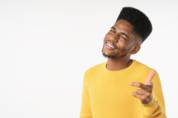 Wall Mural - Portrait of young man pointing with his finger cool expression against white background