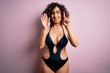 © Krakenimages.com - Young beautiful arab woman on vacation wearing swimsuit and sunglasses over pink background showing and pointing up with fingers number six while smiling confident and happy.