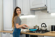 © RomanR - Happy young woman is preparing the diner in the kitchen