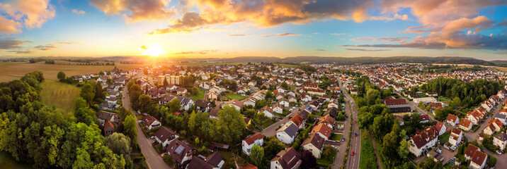 Wall Mural - aerial panorama of a small town at sunrise, with magnificent colorful sky and warm light