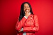 © Krakenimages.com - Young african american woman wearing cool fashion leather jacket over red isolated background with hand on chin thinking about question, pensive expression. Smiling with thoughtful face. Doubt
