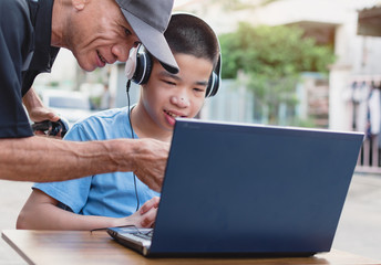 Wall Mural - Special need child on wheelchair use notebook in the house with his parent, Study and Work at home for safety from covid 19, Life in the education age of special need kid, Happy disabled boy concept.