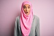 © Krakenimages.com - Young beautiful brunette businesswoman wearing pink muslim hijab and business jacket afraid and shocked with surprise expression, fear and excited face.