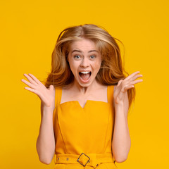 Excited Teen Girl Screaming With Joy Over Yellow Background, Raising Hands