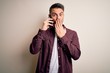 © Krakenimages.com - Young handsome man having conversation talking on the smartphone over white background cover mouth with hand shocked with shame for mistake, expression of fear, scared in silence, secret concept